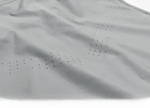 Macro detail of laser-cut breathable micro-pores on gray quick-dry sport fabric