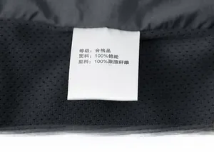 Detailed macro shot of garment wash care label showing 100% nylon and polyester fabrics