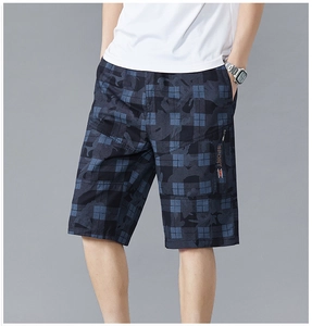 Detail of dark blue camo plaid shorts featuring a zippered cargo pocket with sport print