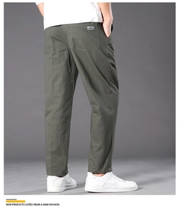 Detail view of olive green cargo pants showing back pocket with brand label