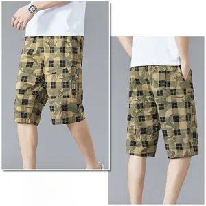Detail of cargo pocket with zipper and SPORT text on green plaid camouflage shorts