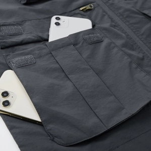 Men's dark gray multi-pocket tactical vest showing large cargo pocket for smartphones