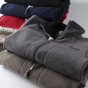 Macro detail of stacked thick fleece jackets with flag embroidery and zipper design