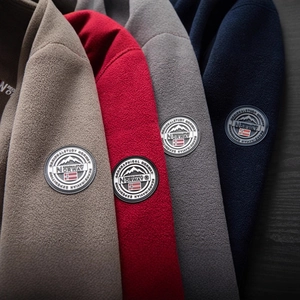 Outdoor fleece jacket featuring badge detailing in khaki, red, grey and navy blue colors