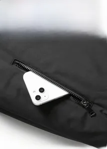 Close-up of a large-capacity zipper pocket on a men's winter jacket with a smartphone for scale