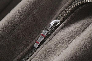 Detail of premium polar fleece fabric and zipper with decorative red stitching puller