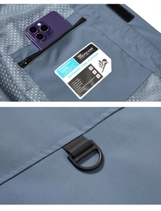 Detail of blue outdoor vest showing large zipper pocket with mesh lining and D-ring