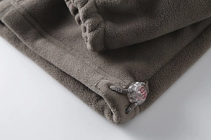 Detailed macro shot of the adjustable drawstring cuff and cord lock on fleece jacket