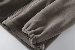 Detail of fleece jacket showing elastic cuffs, smooth zipper and adjustable drawstring hem