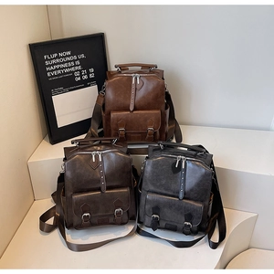 Detailed view of three vintage-style leather backpacks in brown, coffee and charcoal grey