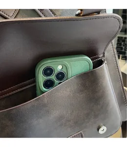 Detailed close-up of dark brown leather backpack showing functional front pocket for smartphone