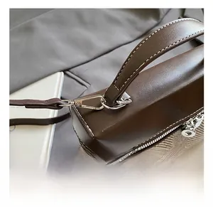 Detail of mixed leather and herringbone fabric handbag with silver metal D-ring hardware