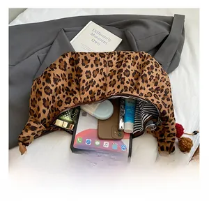 Detail showing high-capacity interior of leopard print crescent bag with daily essentials