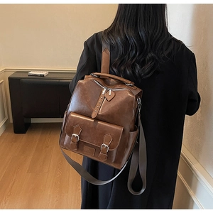 Close-up of vintage brown PU leather backpack with magnetic metal buckle and side pockets