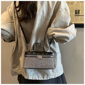 Détail du petit sac bicolore avec tissu à chevrons et longue bandoulière en cuir