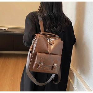 Rear view of vintage dark brown leather backpack with multiple pockets and metal buckles