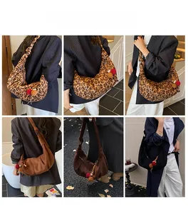 Detail view of hobo bag in leopard print, brown suede, and black with colorful pom-poms