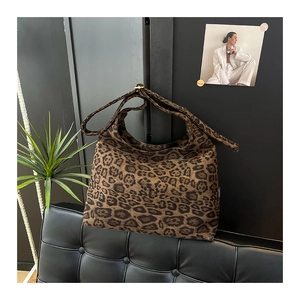 Dettaglio della borsa tote scamosciata leopardata appesa in un interno moderno