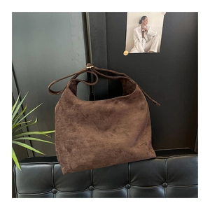 Dettaglio borsa hobo grande in pelle scamosciata marrone con fibbia dorata e tracolla