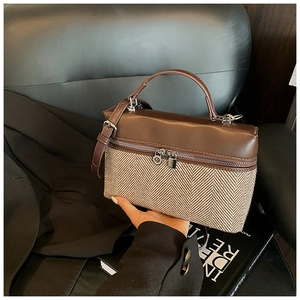 Détail du sac bicolore avec tissu à chevrons et finitions en cuir marron de qualité
