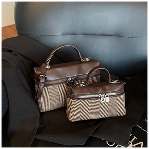 Détail de l'ensemble de deux sacs à main en cuir marron et tissu à chevrons sur une chaise