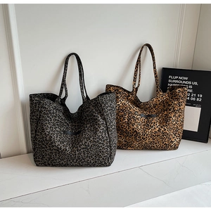Close-up of leopard print canvas tote bags in gray and brown with leather patches