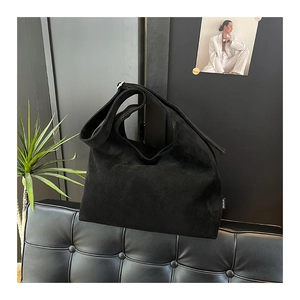 Dettaglio della borsa hobo in pelle scamosciata nera con trama opaca ed etichetta moda