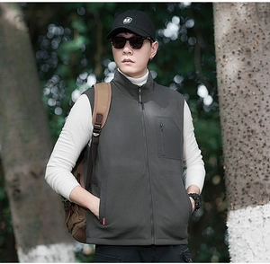 Detail of grey fleece vest featuring a stand-up collar and vertical chest zipper pocket