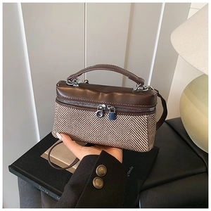 Détails de la texture bicolore et du petit cadenas en métal sur un mini sac à main rétro