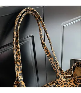 Close-up of leopard print canvas tote bag straps with reinforced stitching detail