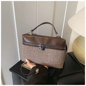 Détail du sac bicolore avec tissage à chevrons et poignée supérieure en cuir marron