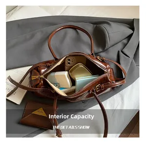 Detail showing inner capacity of vintage brown patent leather bag with a matching small pouch