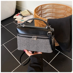 Détail du sac boîte bicolore avec fermetures éclair doubles et tissu à chevrons tissé