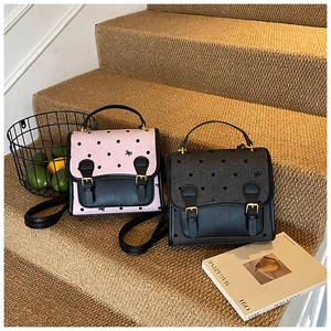 Retro preppy polka dot backpacks in pink and grey colors on a carpeted staircase