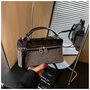 Détail du sac de style boîte à lunch bicolore avec tissage à chevrons et cuir noir