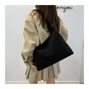 Dettaglio della borsa tote grande in camoscio nero con trama morbida e drappeggio a spalla