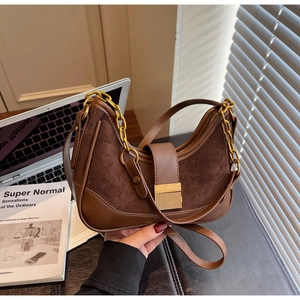 Detail of vintage brown patchwork underarm bag with gold metal buckle and chain strap