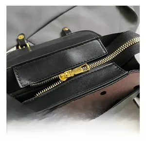 Detail of golden metal zipper and polka dot lining inside a black leather backpack