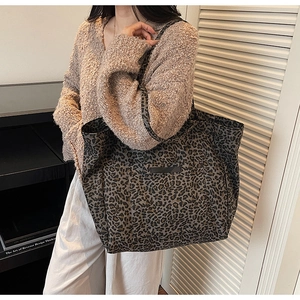 Close-up of leopard print canvas tote bag with front pocket detail and durable straps