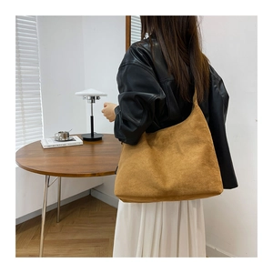 Dettaglio della borsa hobo in pelle scamosciata marrone indossata da una modella