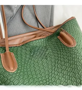 Close-up of retro green woven texture and brown leather label on a large tote bag