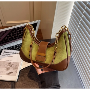 Detail of green suede and brown leather patchwork bag with gold chain strap and buckle