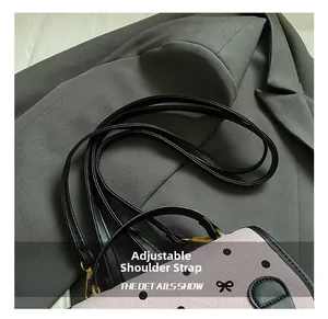 Detailed view of adjustable black leather strap with metallic clasp on polka dot backpack