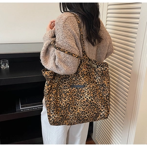 Detailed back view of large leopard print tote bag worn over the shoulder by a model