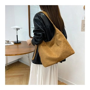 Vista dettagliata della grande borsa tote in pelle scamosciata marrone indossata da modella