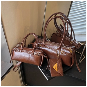 Detailed close-up of retro brown barrel bags set with vintage pleated faux leather texture
