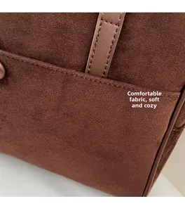 Detail of soft brown suede fabric texture and stitching on a large commuter tote bag