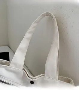 Detail view of the durable canvas tote bag handle with high-quality black fastener