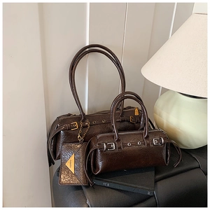 Detail showing vintage dark brown oil-wax leather texture and stylish metal belt buckles