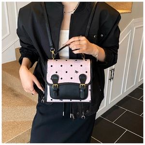 Detailed view of pink polka dot canvas bag with bow pattern and golden buckles